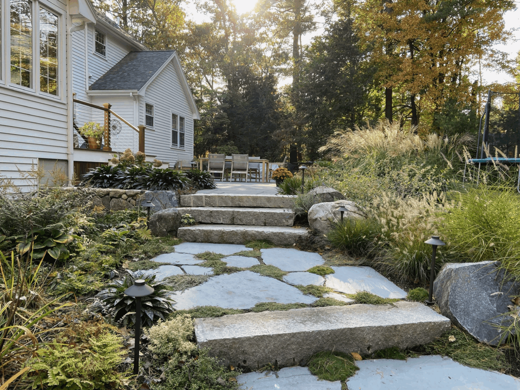 stone steps leading up to a patio with low lights lining either side of the steps.