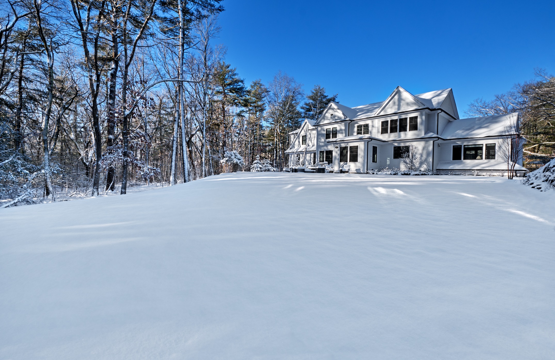 Suburban home on a cold, sunny Winter morning with the back yard covered in snow